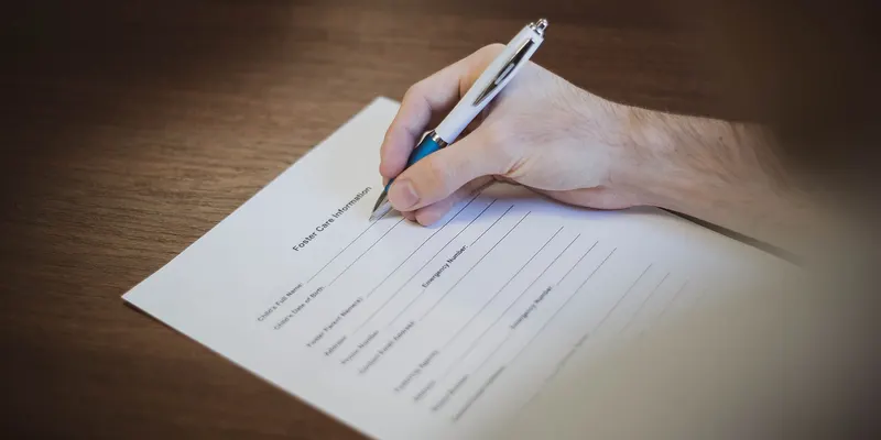 Une main signe un document avec un stylo.