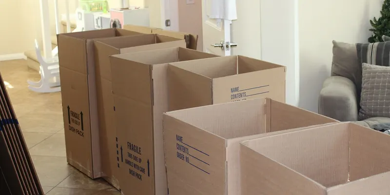 Des cartons de déménagement ouverts dans une pièce vide.