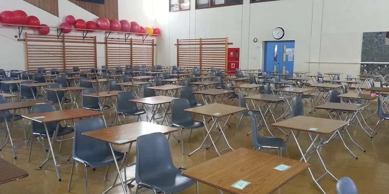 Une salle d’examen avec des tables individuelles alignées.